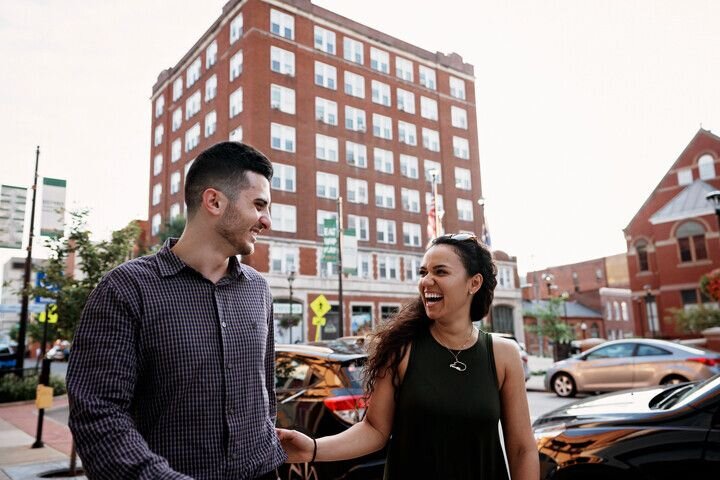 A couple walking down the street laughing in Morgantown, West Virginia.