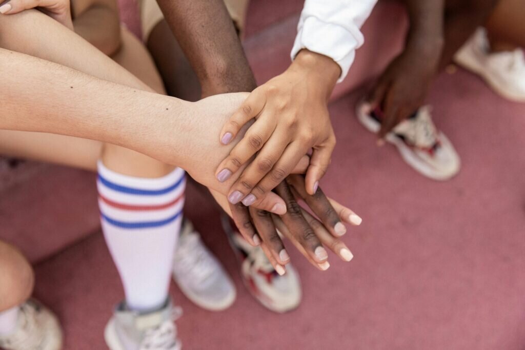 People sit with their hands stacked on top of each other.