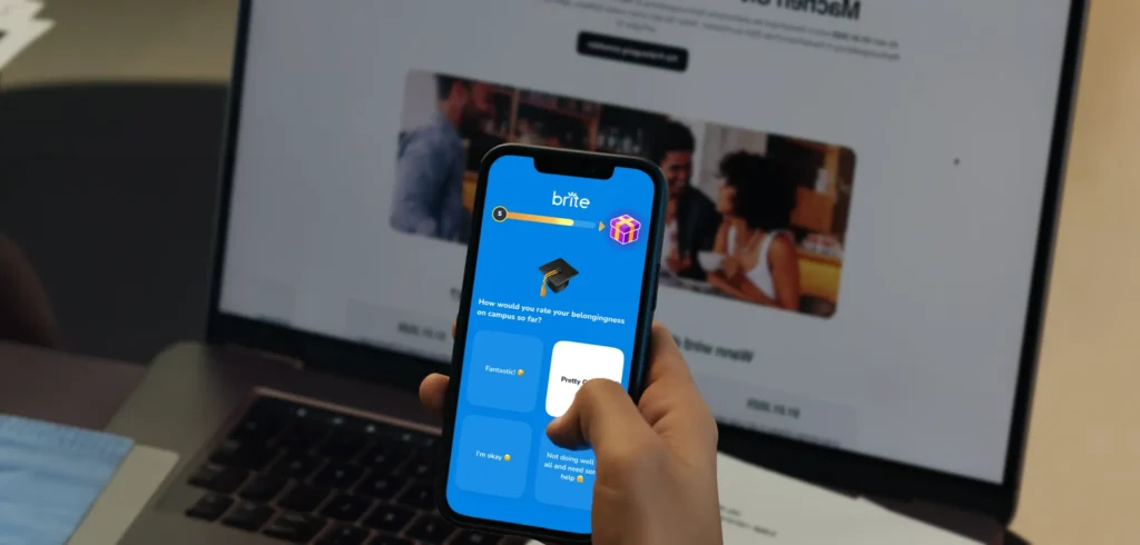 Photo of a college student holding a phone with the Brite app pulled up.