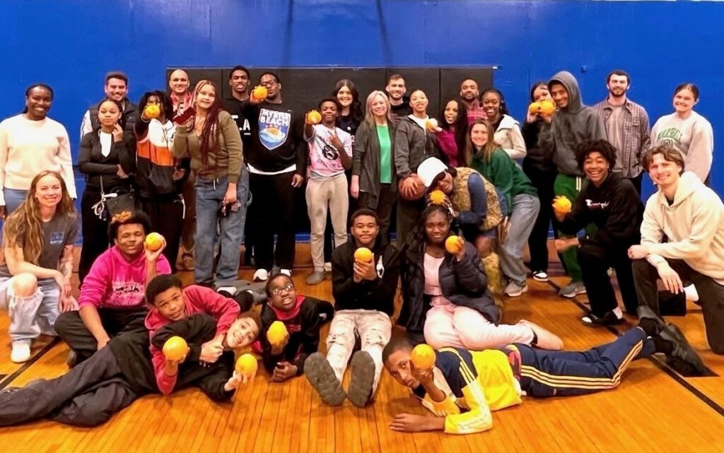 A group of students and mentors in an indoor basketball court 